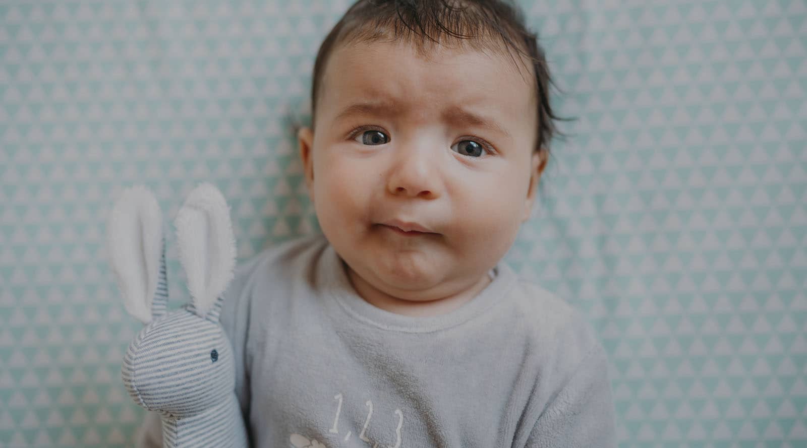Newborn baby looking uncomfortable and fussy