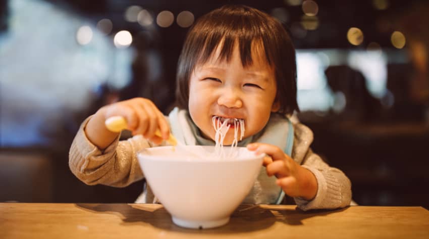 Toddler eating a bowl of noodles Toddler eating a bowl of noodles