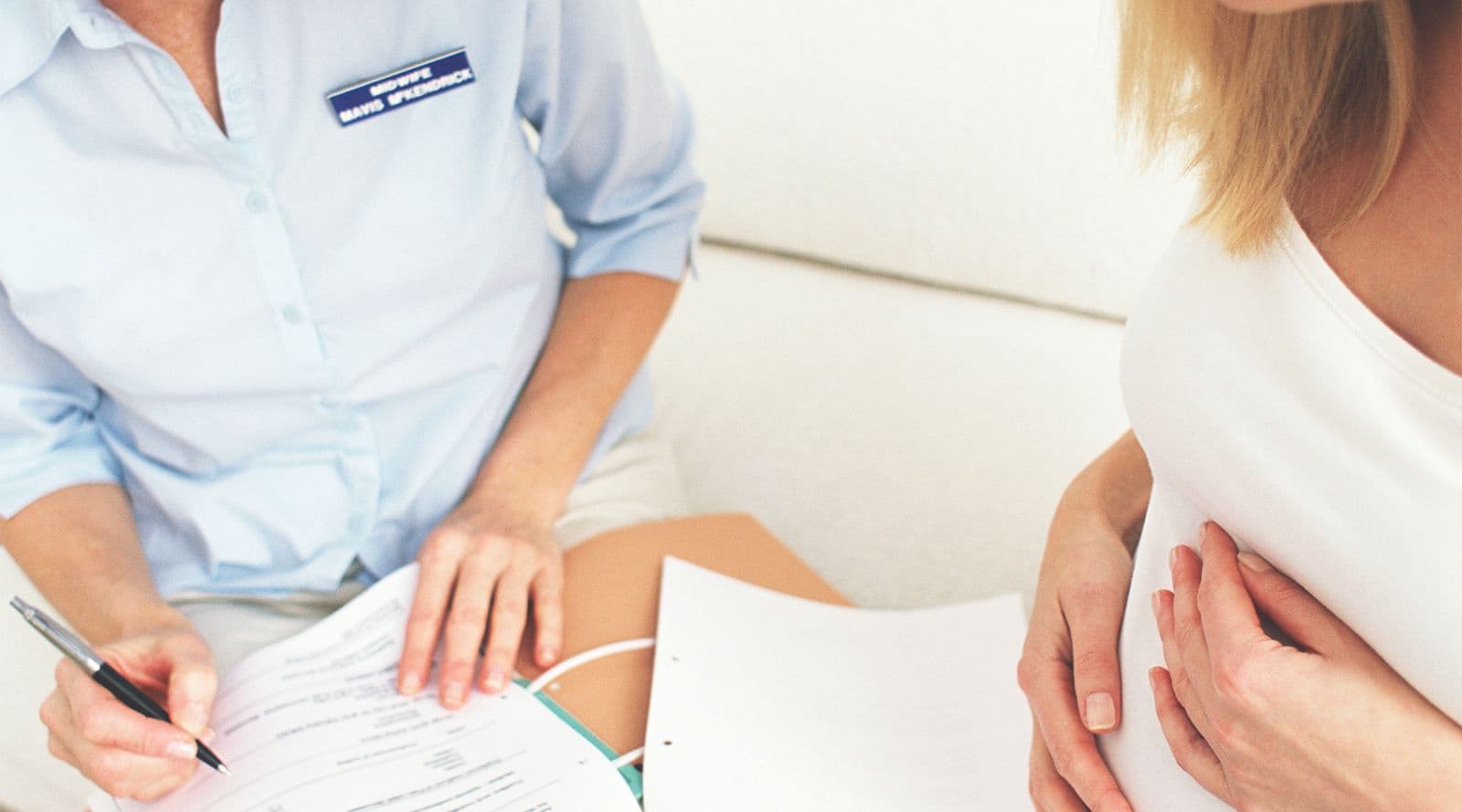 Midwife writing a pregnant mother’s maternity notes