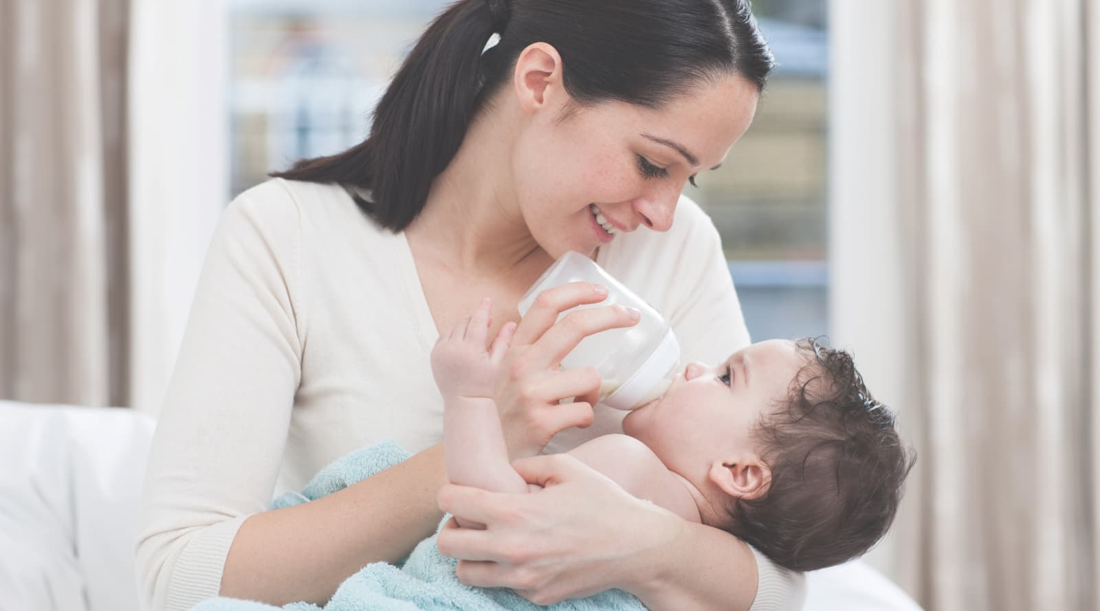 Woman bottle feeding a baby in her arms