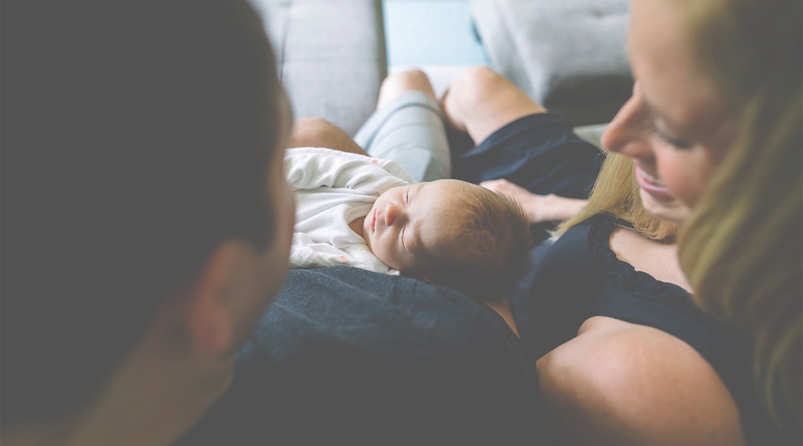 parents cuddling their new born baby
