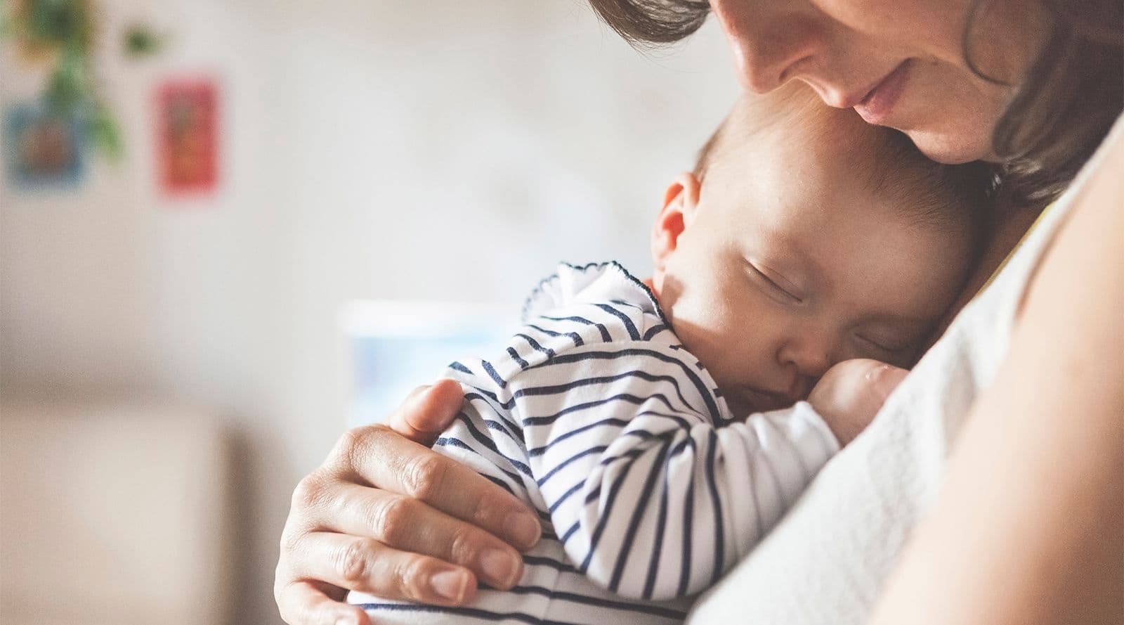 baby sleeping in mother’s arms