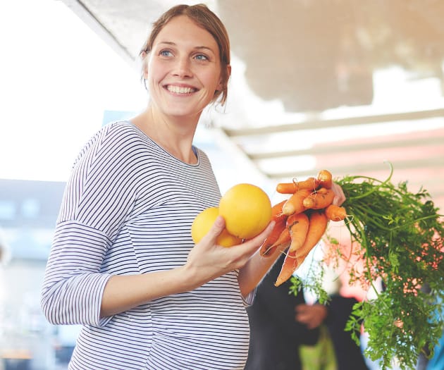 Pregnant mother shopping for organic fruits and vegetables