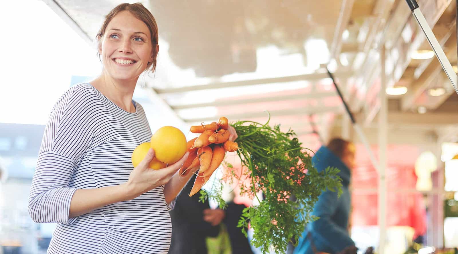Pregnant mother shopping for organic fruits and vegetables